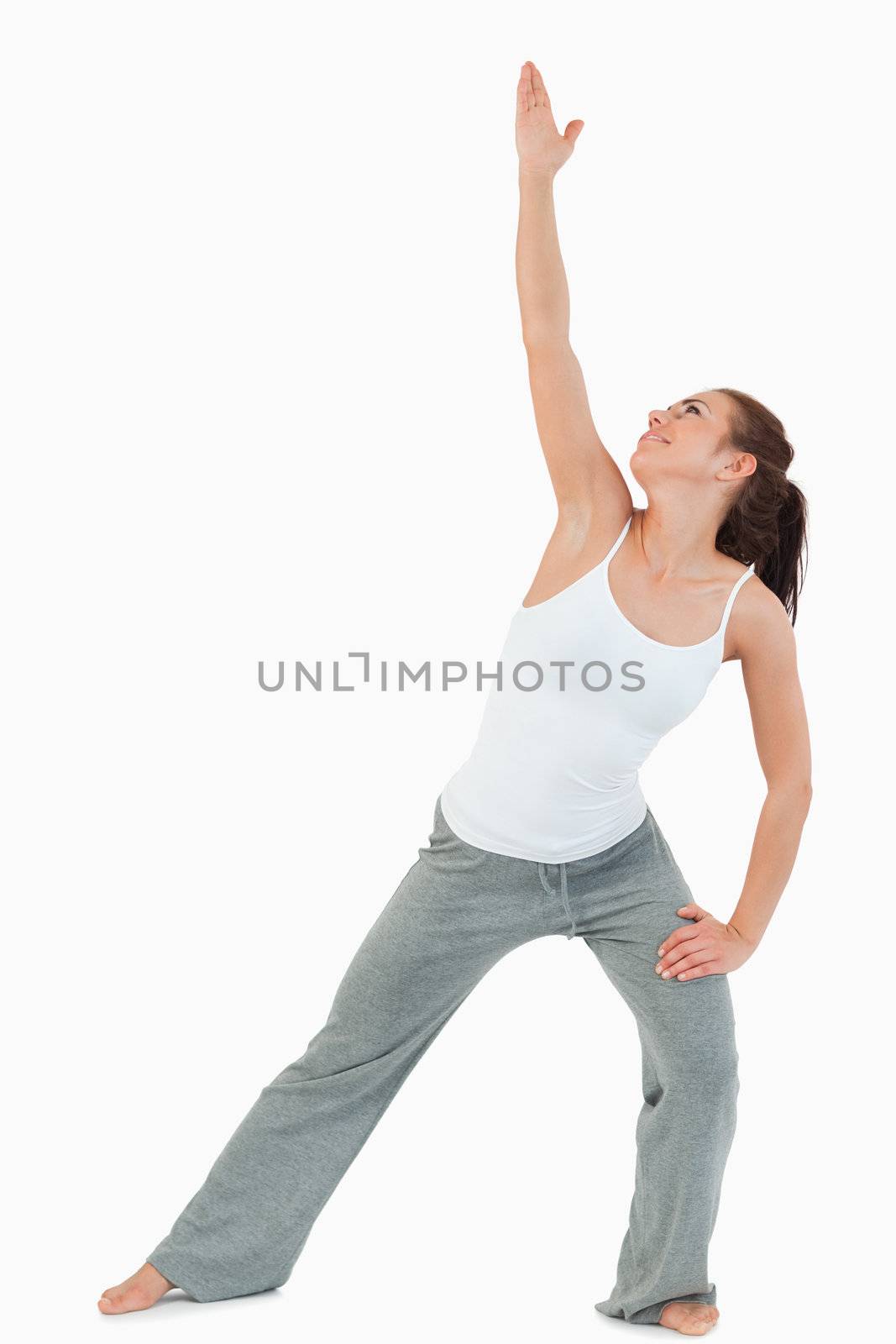 Portrait of a woman in the Utthita Trikonasana position against a white background