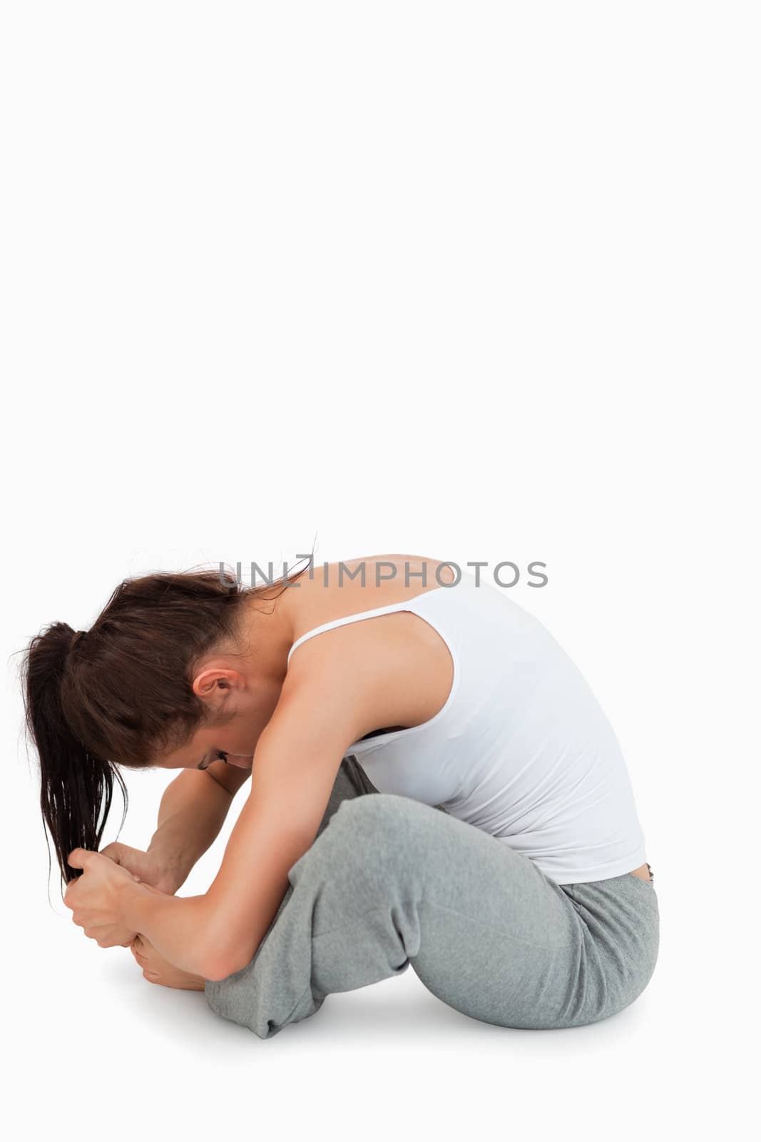 Portrait of a woman stretching her legs against a white background