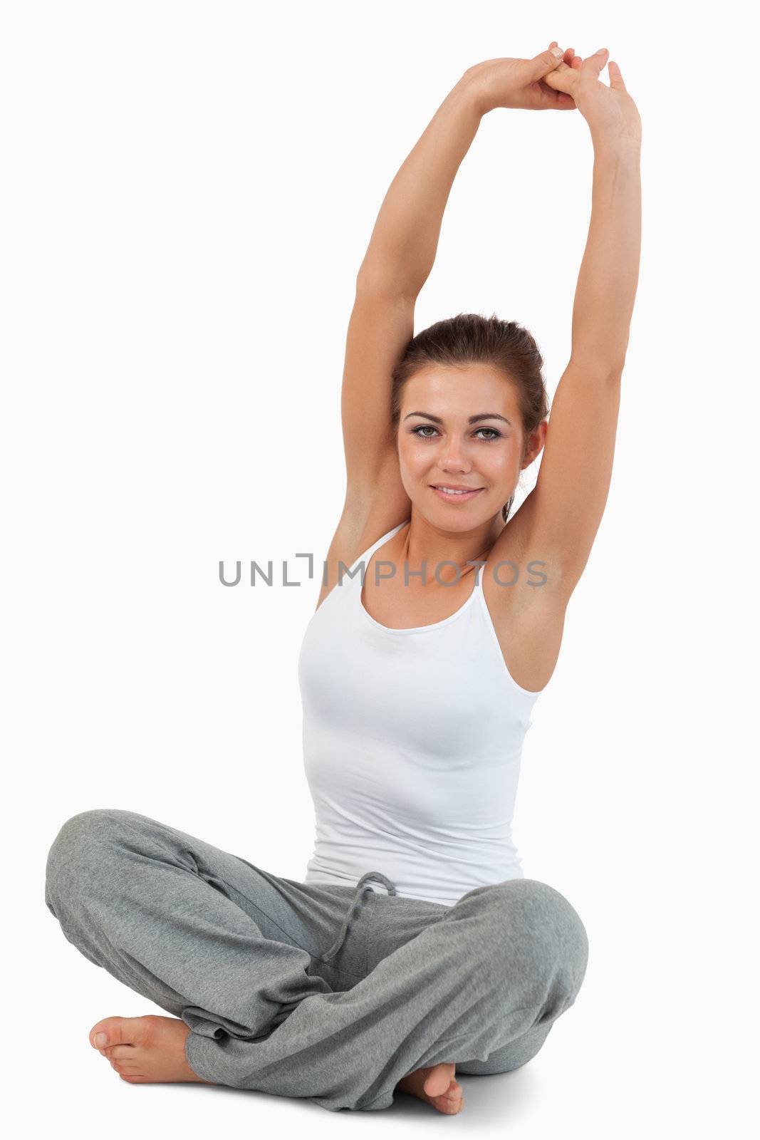 Portrait of a woman stretching her back against a white background