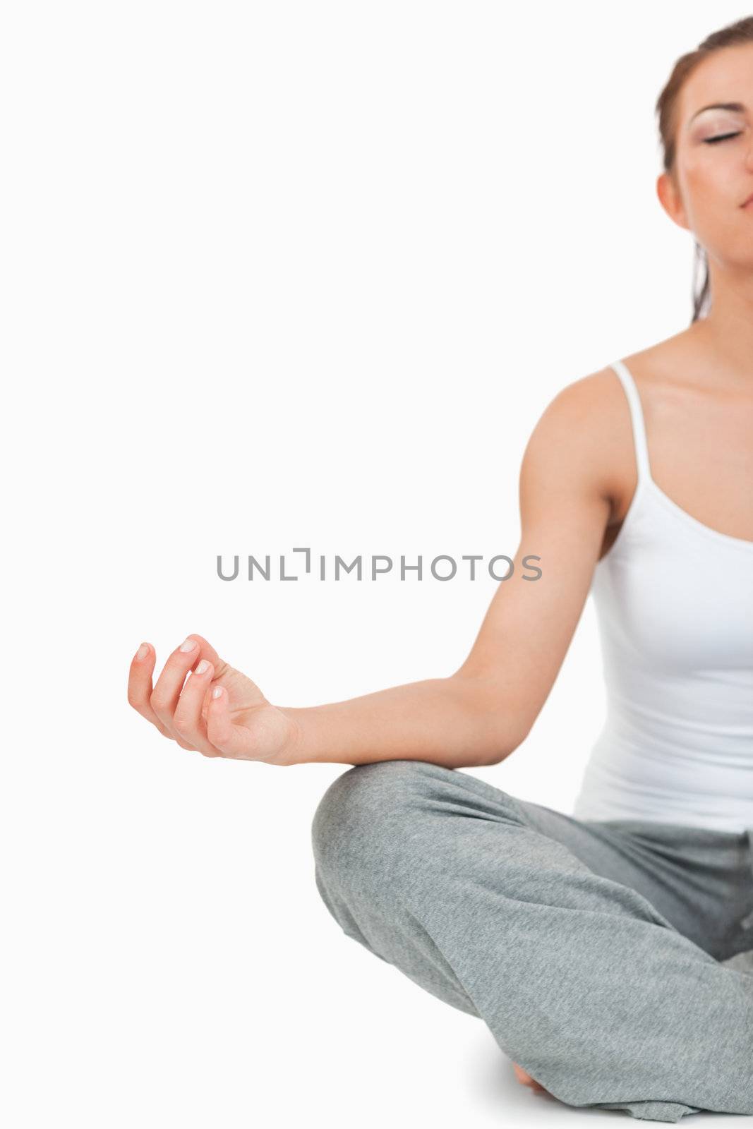 Portrait of a meditating woman in the Sukhasana position against a white background