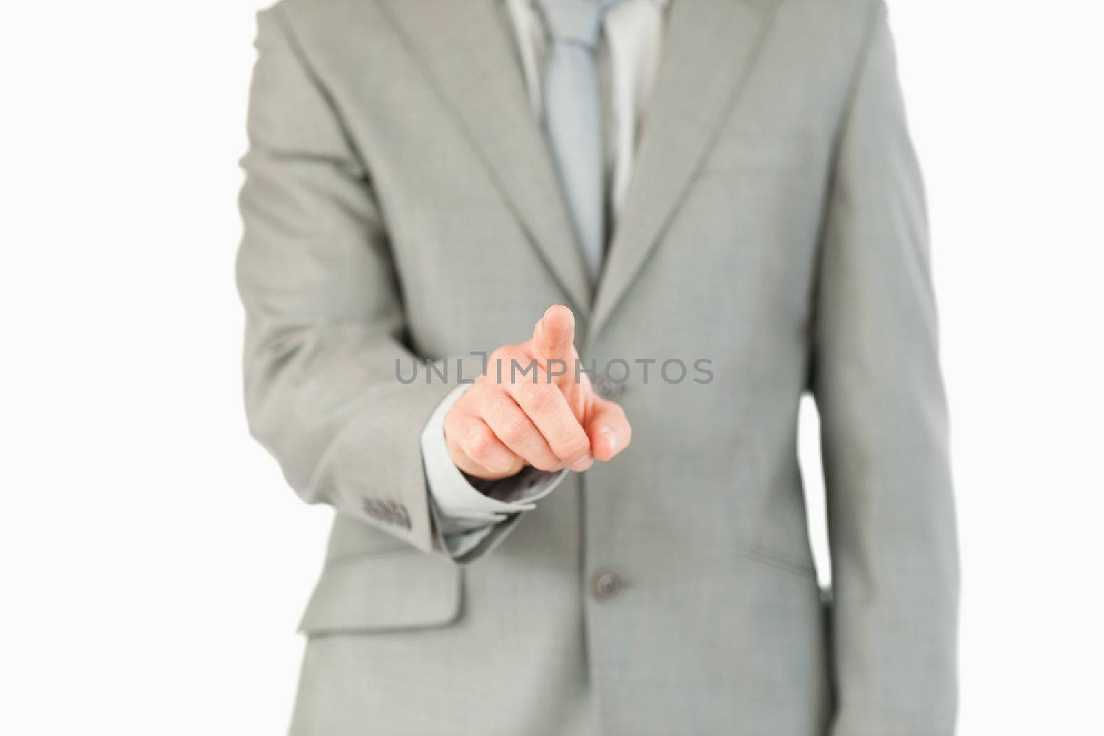 Businessman's finger activating futuristic touchscreen against a white background