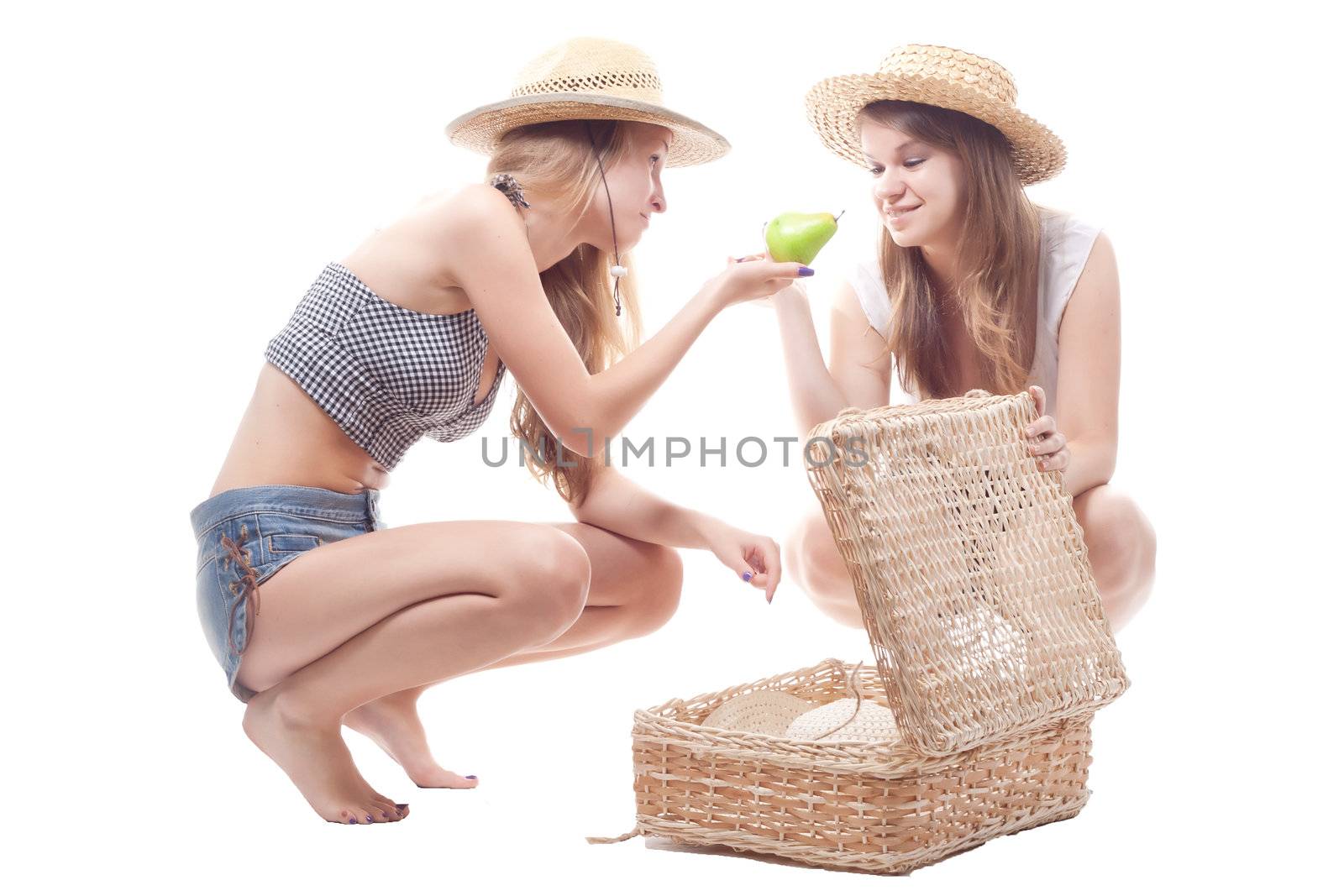 Two girls in straw hats with a straw suitcase, studio photography