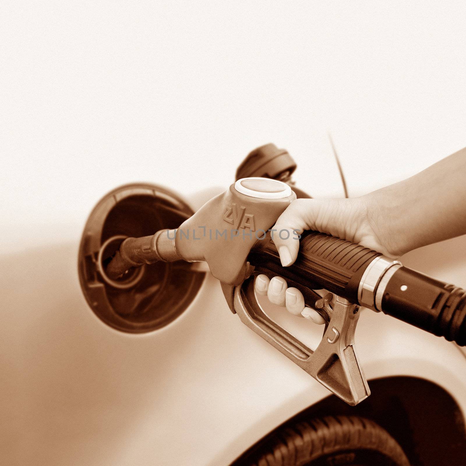 A woman's hand taking gas - sepia tone