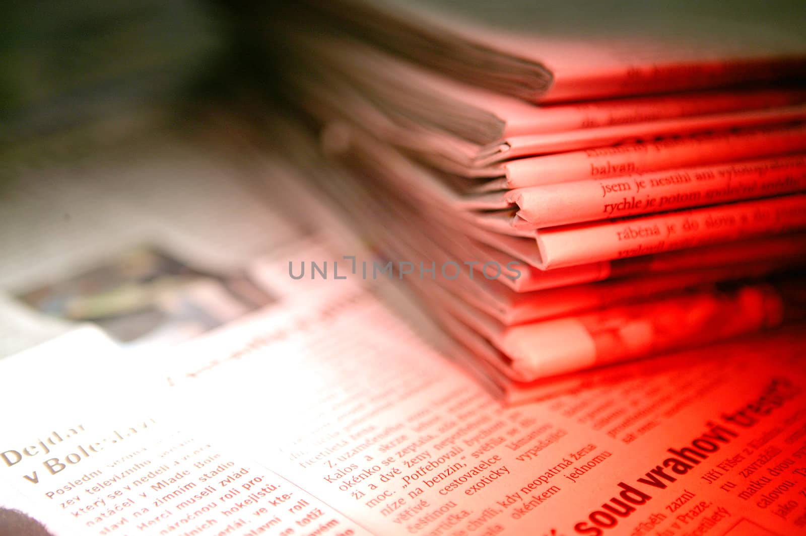 A detail of a pile of newspaper in red light