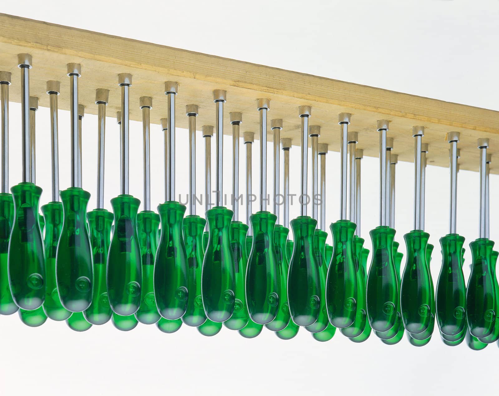 A large set of green screwdrivers in a row