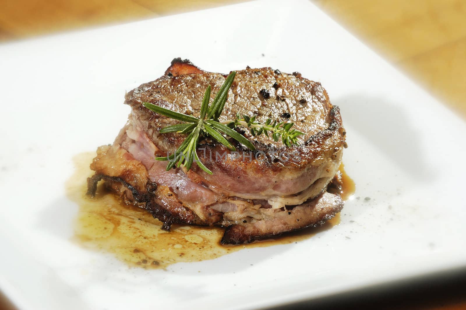 Beefstake with the rosemary on the white plate