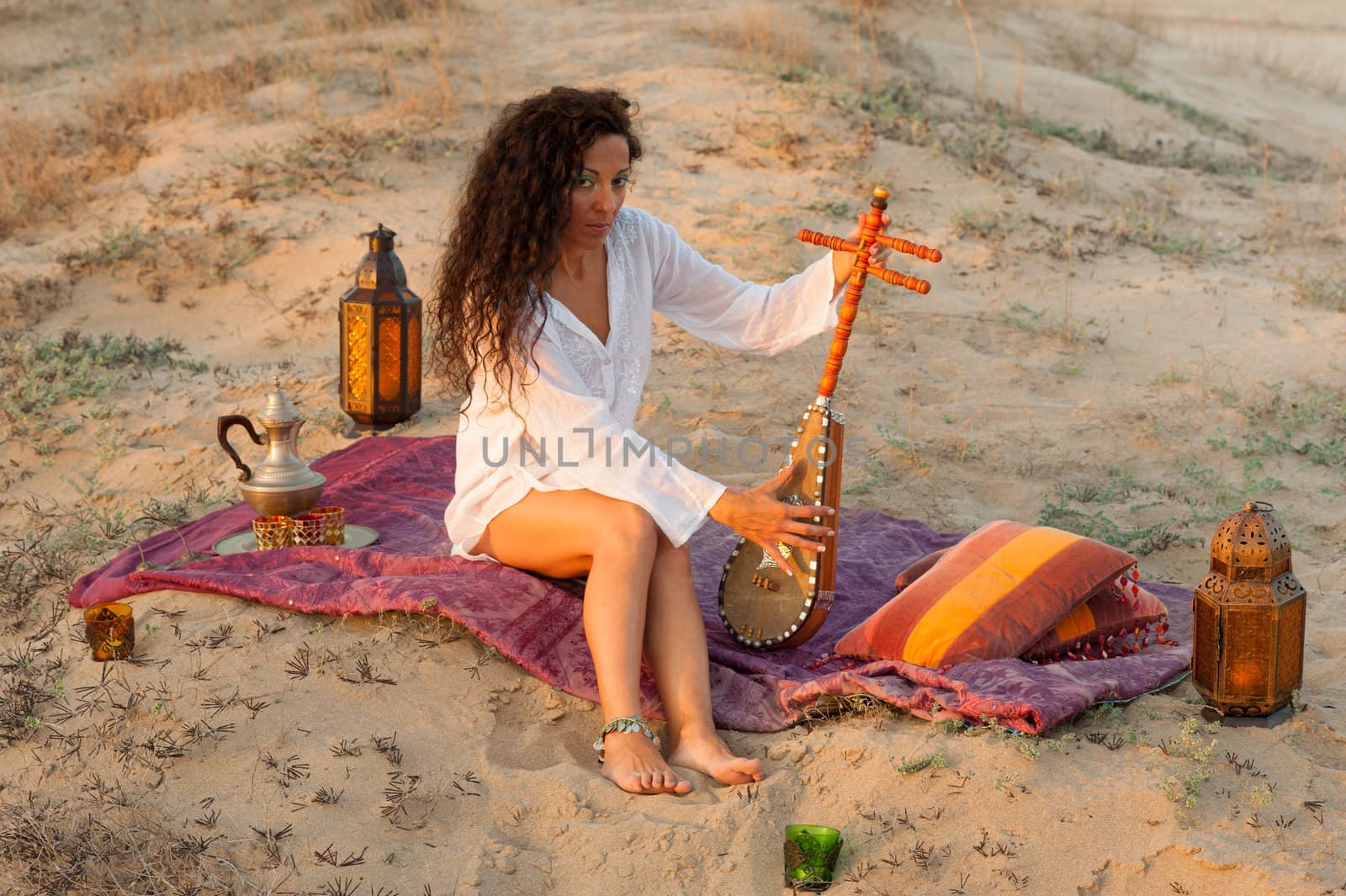 Woman with a sitar in a desert  setting