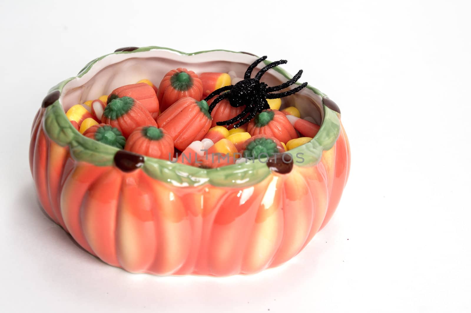 Candy corn in halloween dish with black toy spider