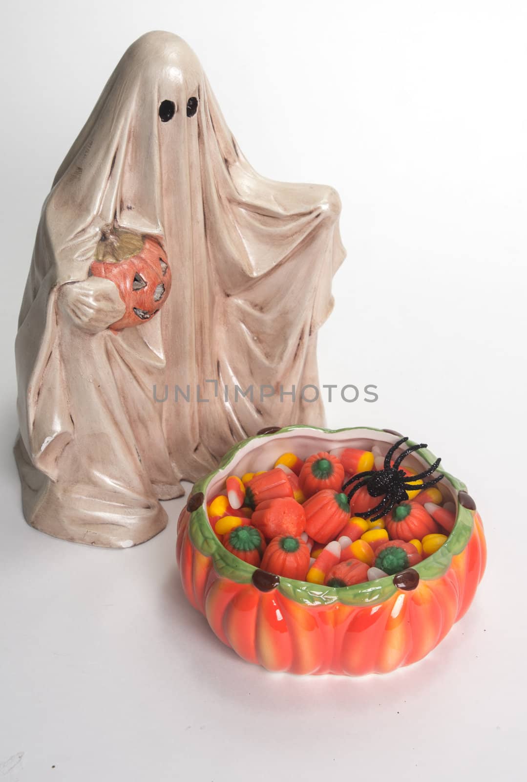 Halloween ghost with Jack O'Lantern and candy corn filled candy dish isolated on white background