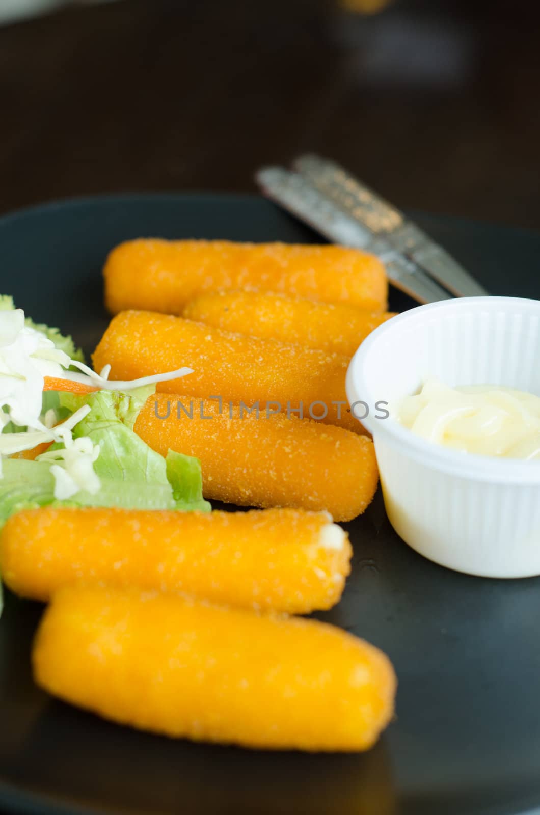 fried cheese with mustard served on dish in restaurant