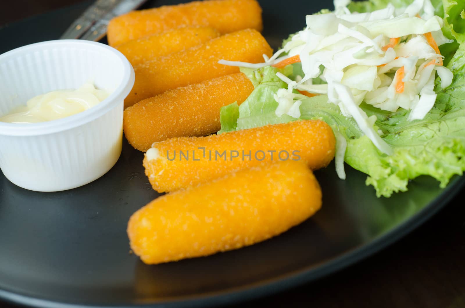 fried cheese with mustard served on dish in restaurant