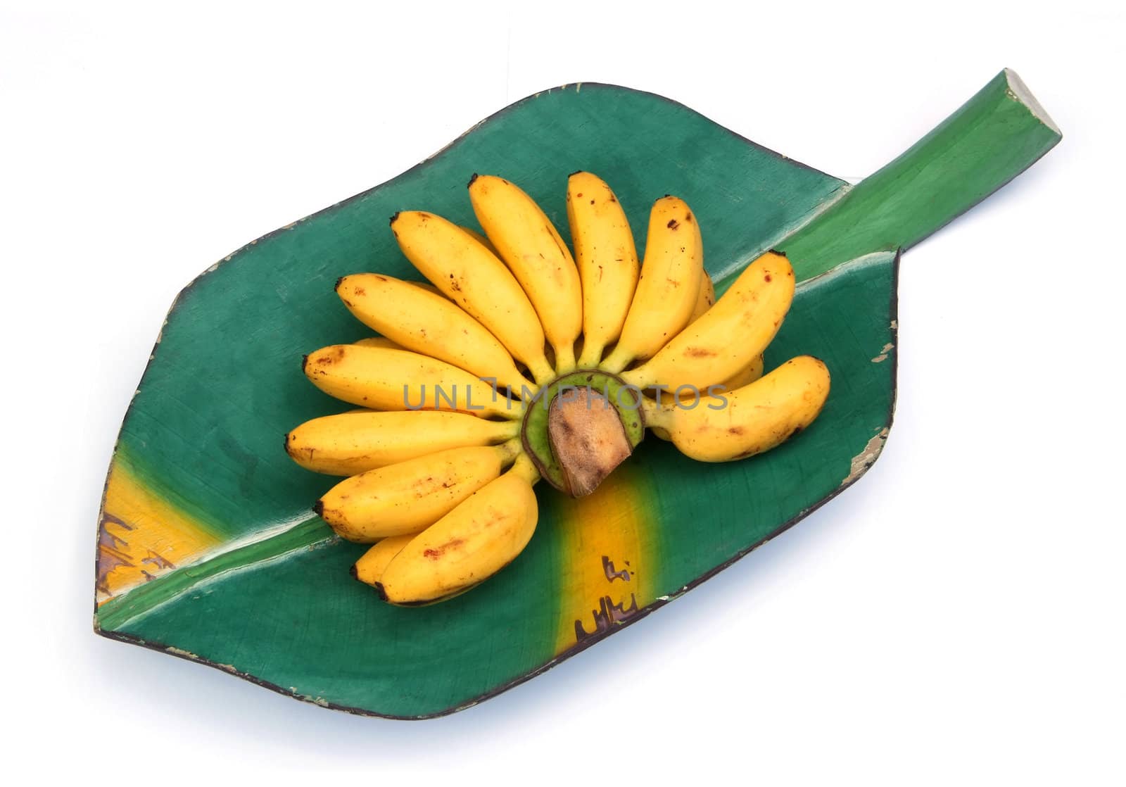 Bunch of bananas on a banana leaf, wooden tray isolated over white background 
