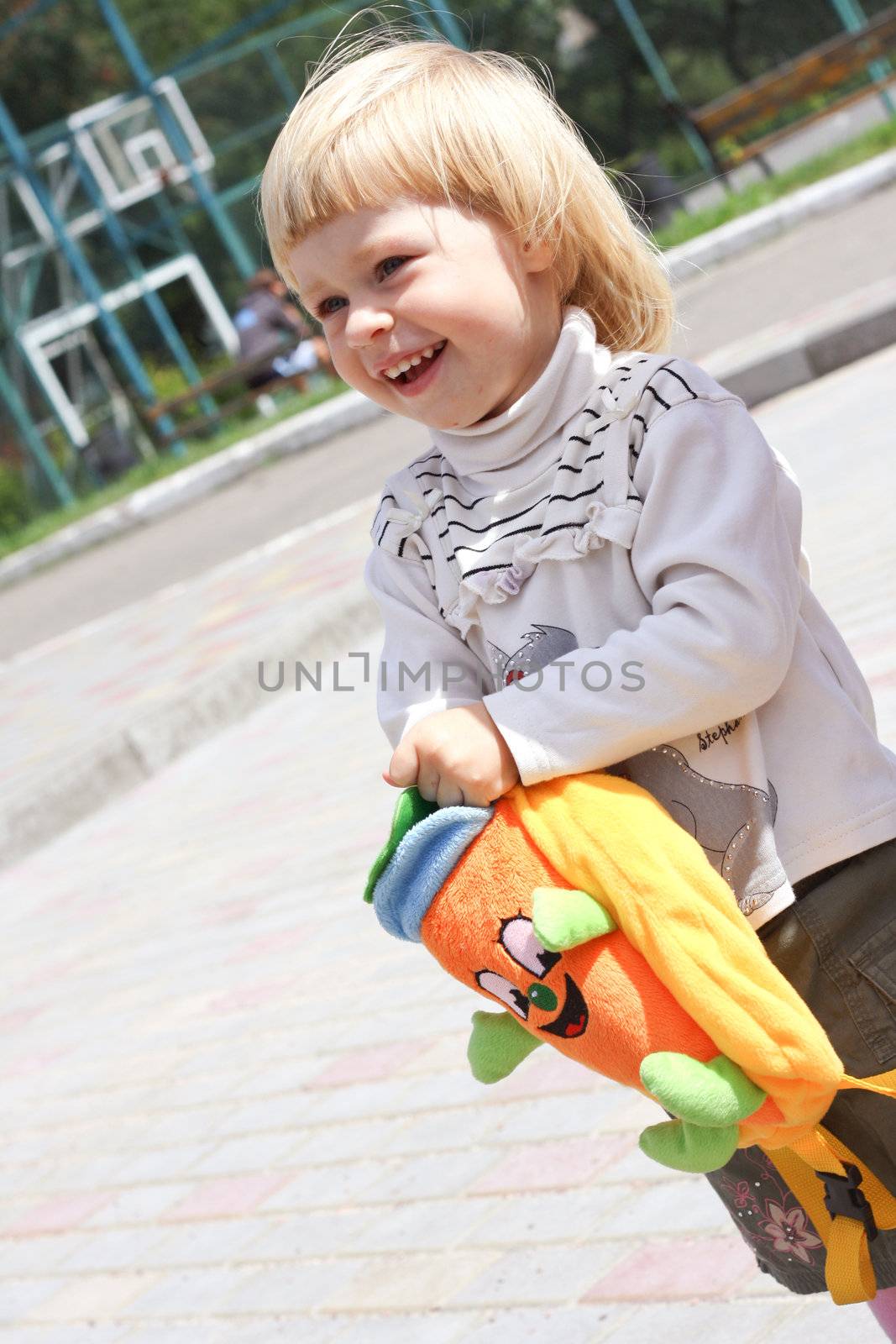 Little girl with plush bag shooting in the park
