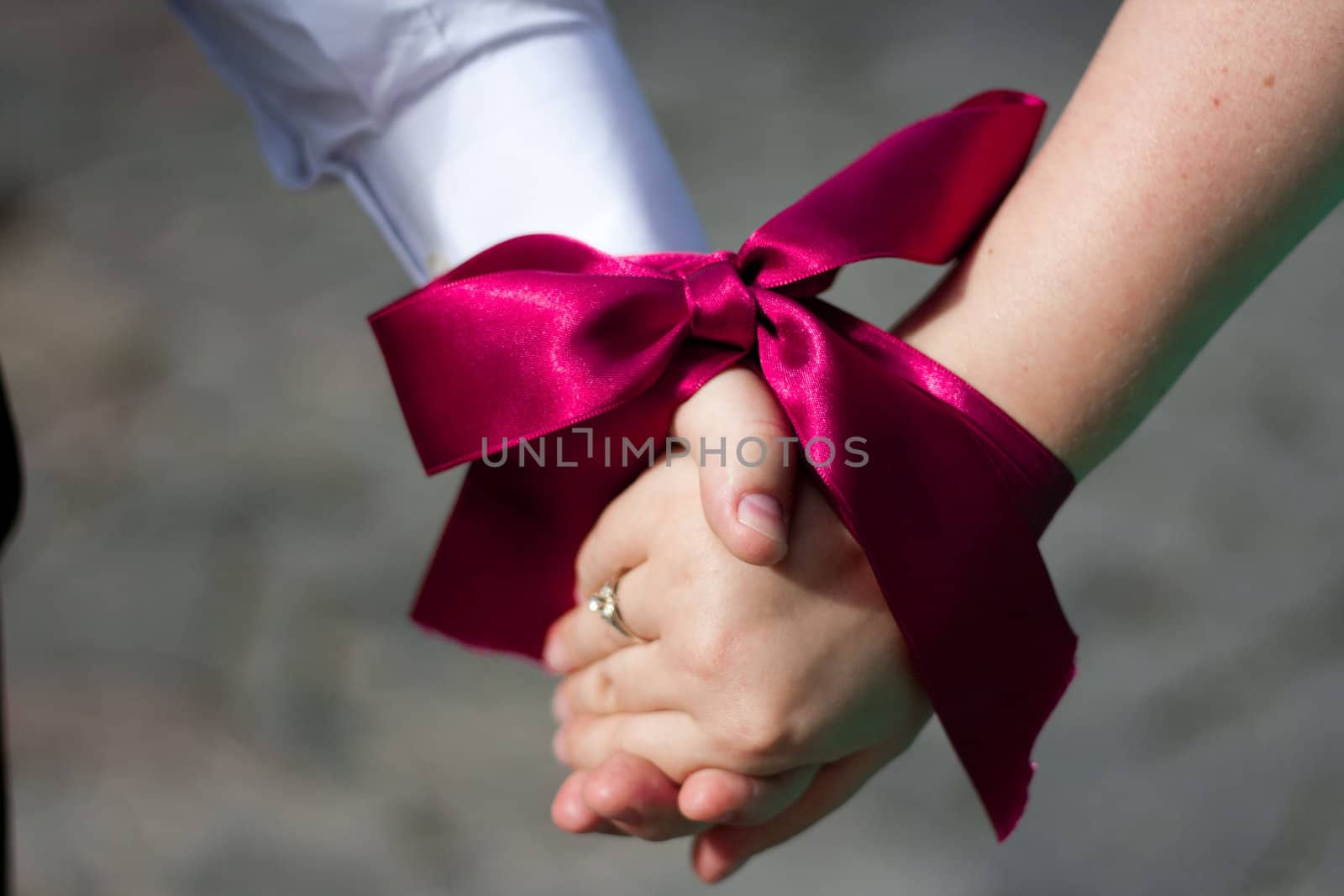 Wedding ceremony - Hands of women and men are associated with red ribbon