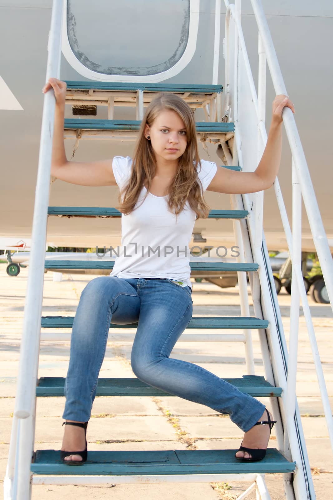 Beautiful girl sitting on the airplane gangway by victosha