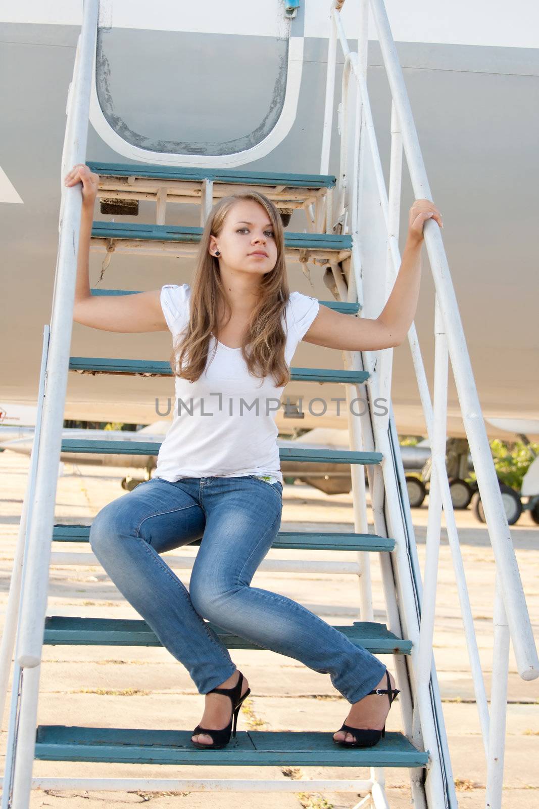 Beautiful girl sitting on the airplane gangway by victosha