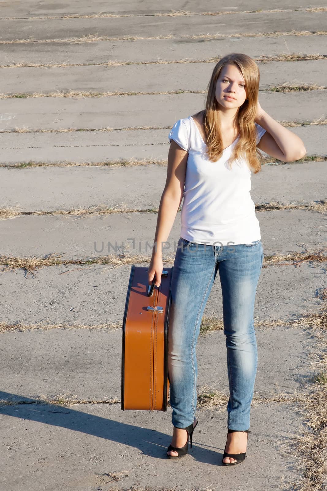 beautiful girl with a suitcase outdoors shooting