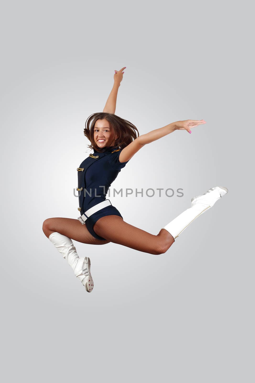 Young female dancer jumping against white background