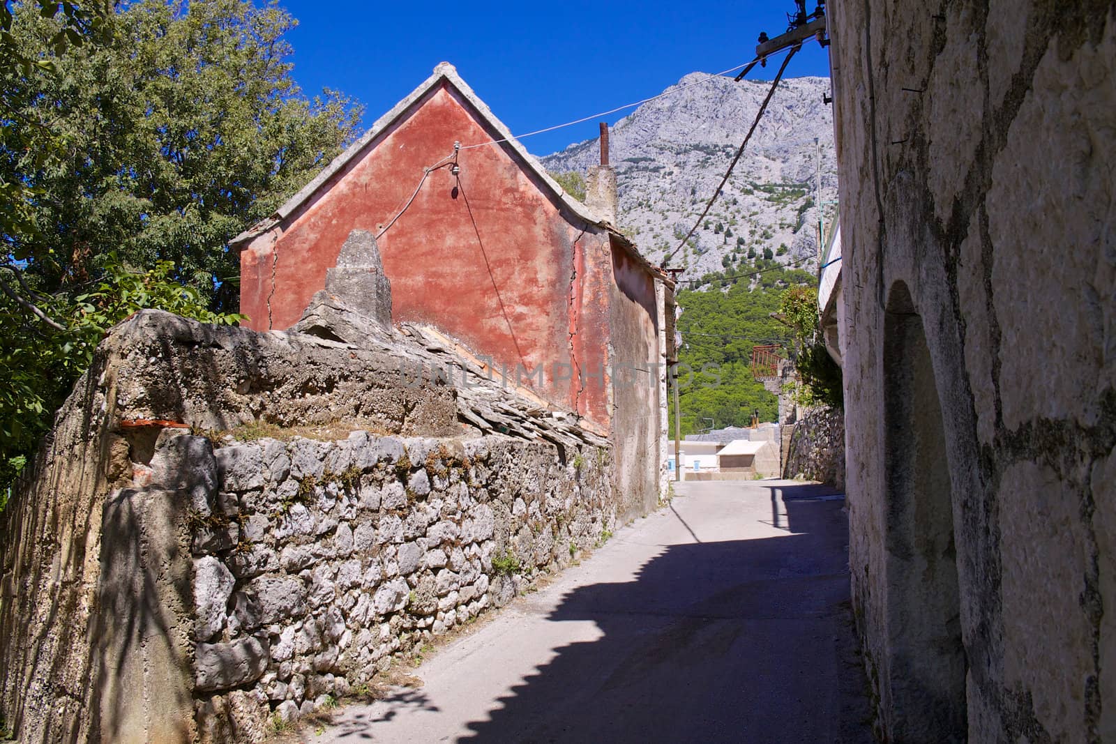Street in old village of Tucepi with typical stone houses on Makarska Riviera in Dalmatia, Croatia