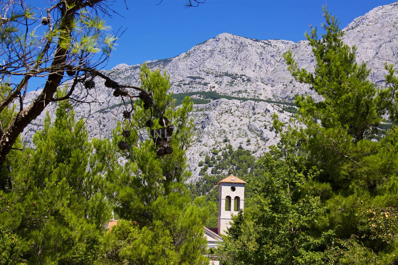 Church in old village of Tucepi below towering mountains of Biakovo nature park on Makarska Riviera in Dalmatia, Croatia