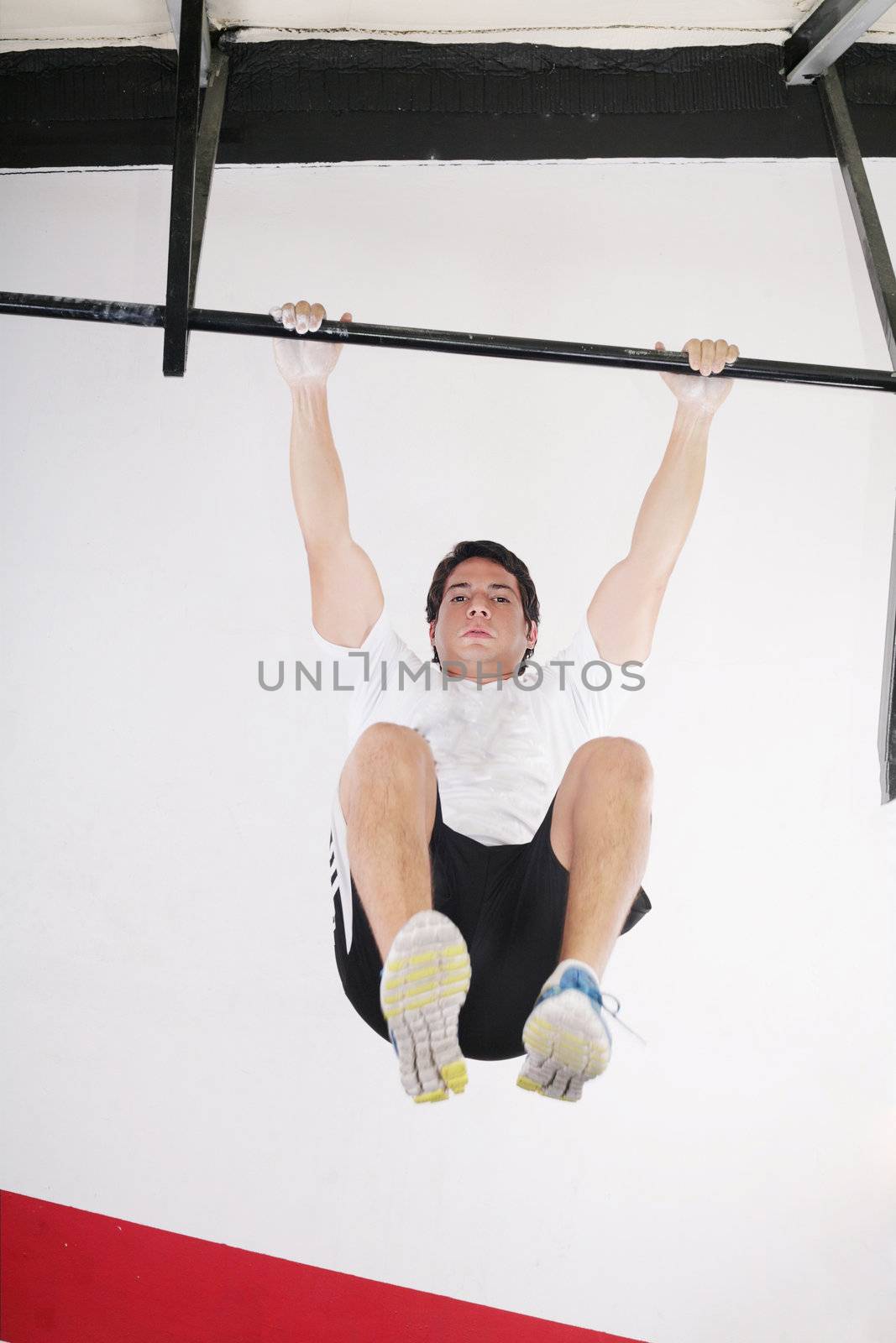 fit man performing pull ups in a bar