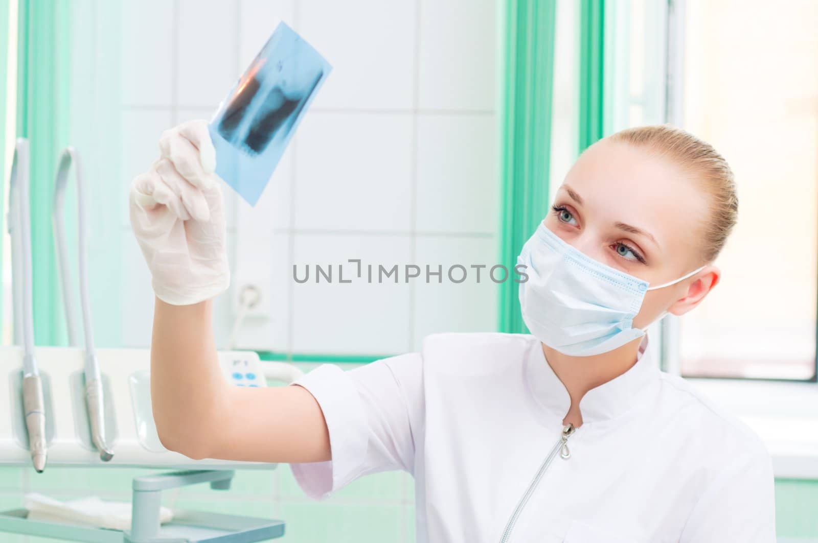 woman doctor in protective mask looking at x-ray by adam121