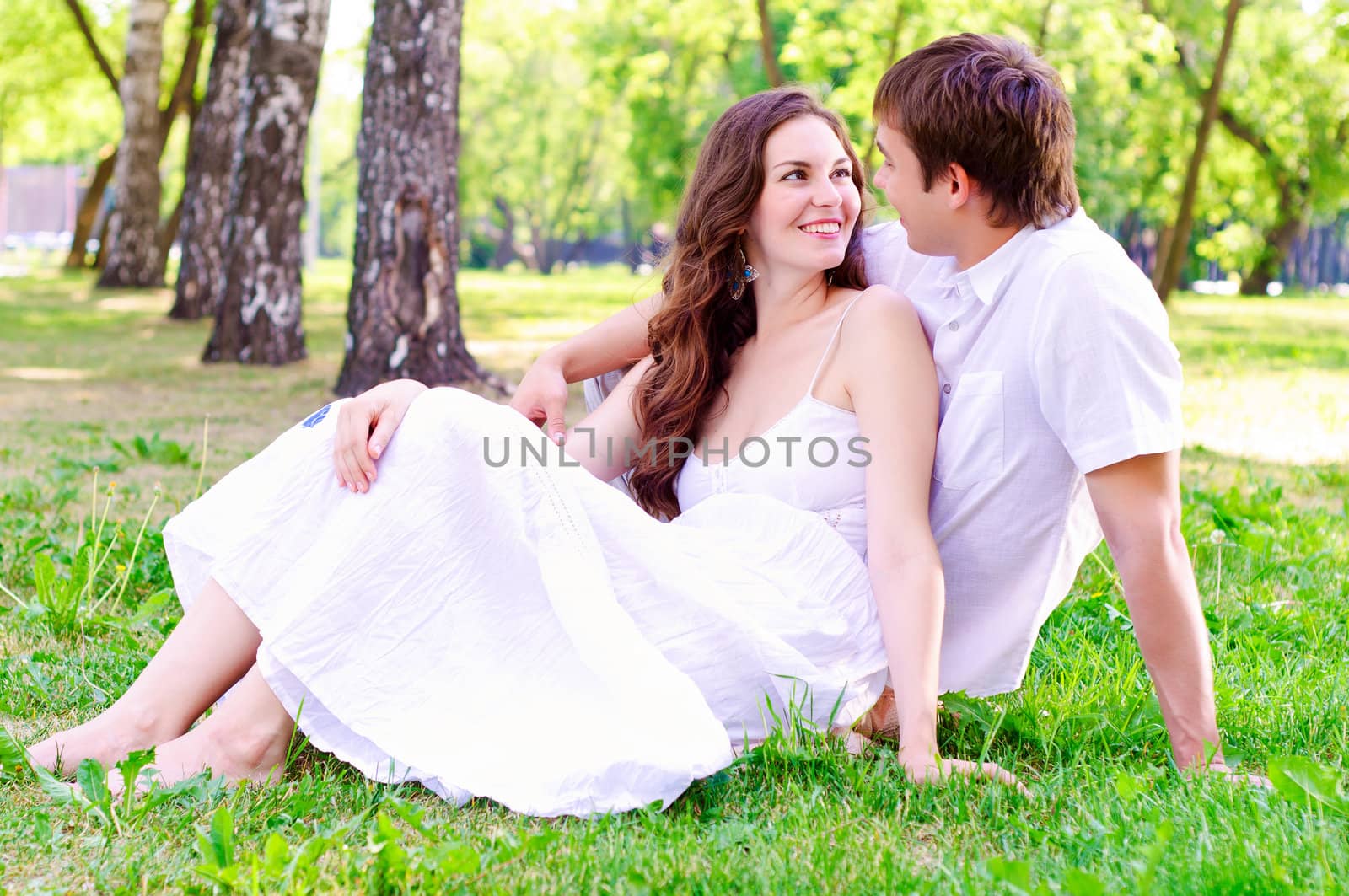 couple in the park sitting on the grass, have a good time together