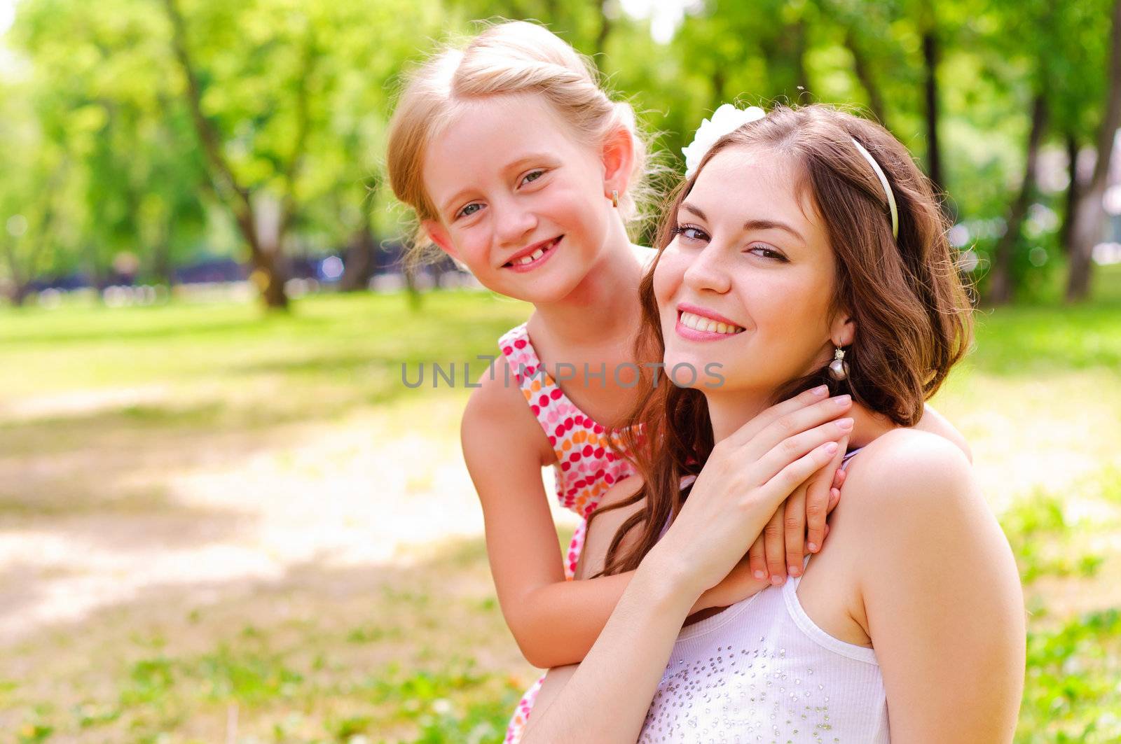 mother and daughter sitting together on the grass, and spend time with family