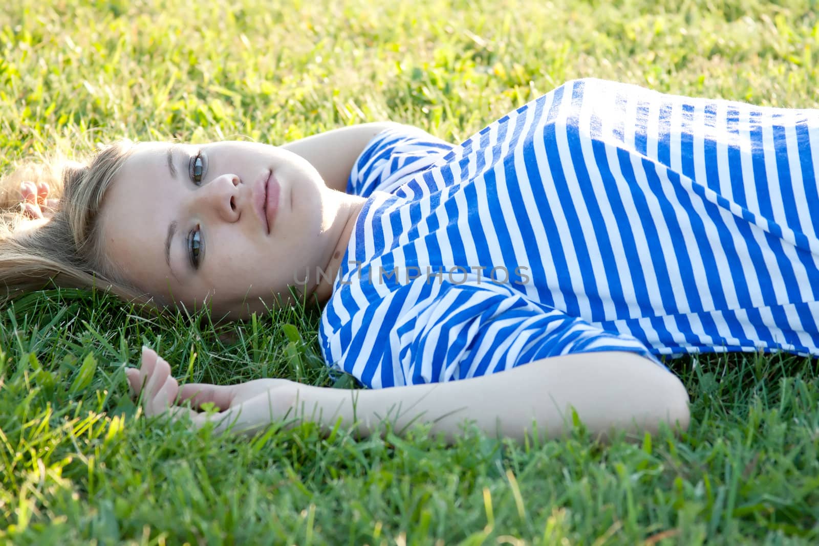 beautiful girl in the shirt on the grass outdoors shooting