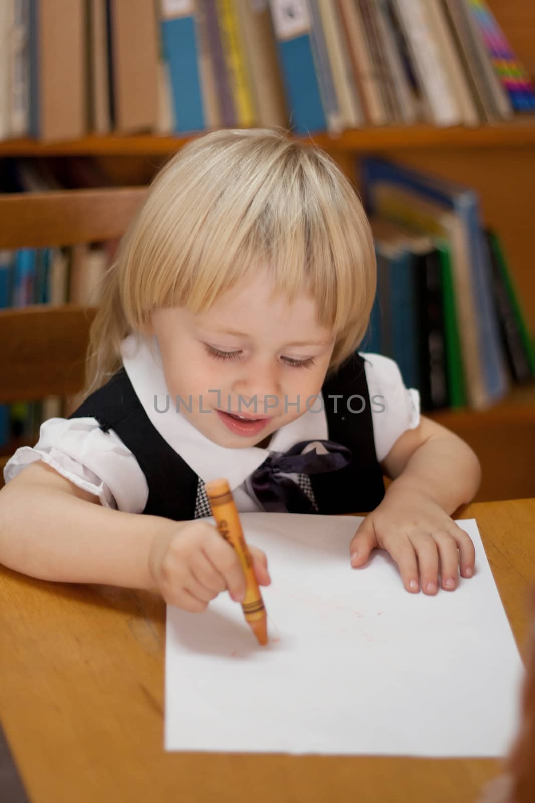 little girl drawing on a white sheet in the library