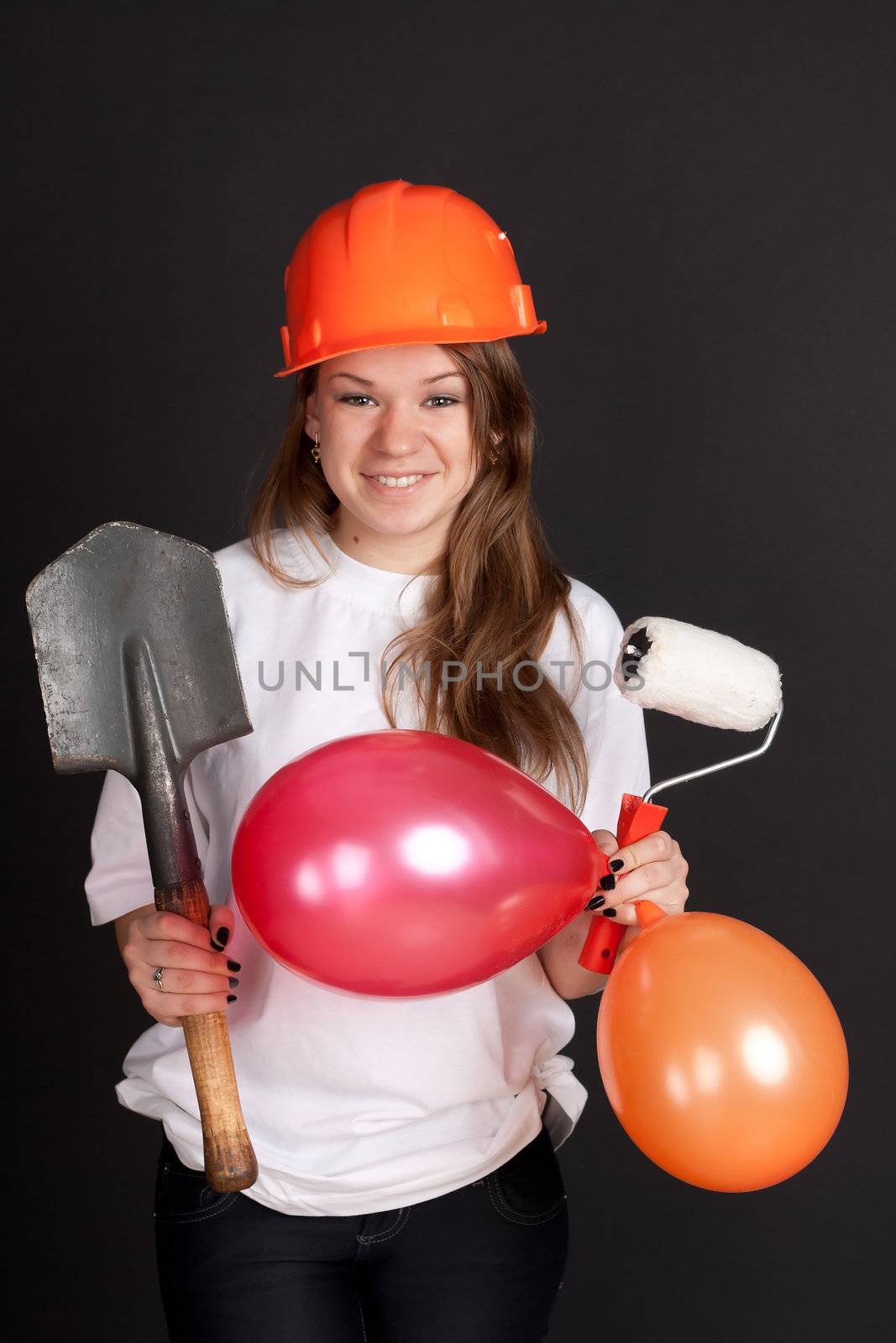 The girl in the orange helmet with balls and a shovel