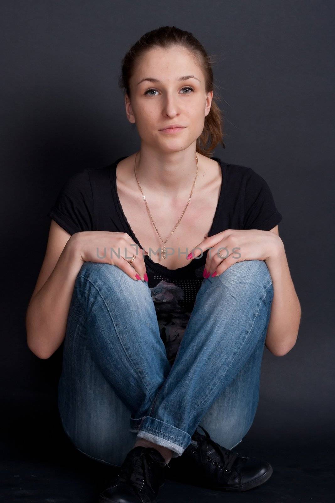 young girl sitting on the floor with crossed legs