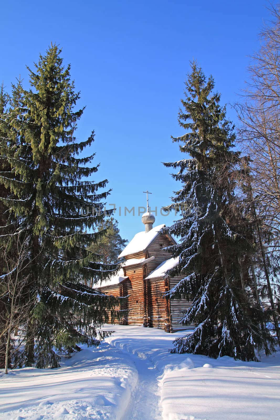 wooden chapel amongst snow tree