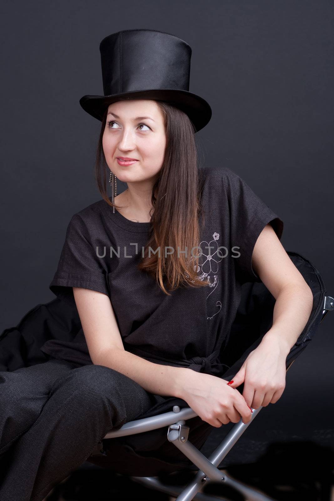 beautiful smiling girl in a black hat on a dark background