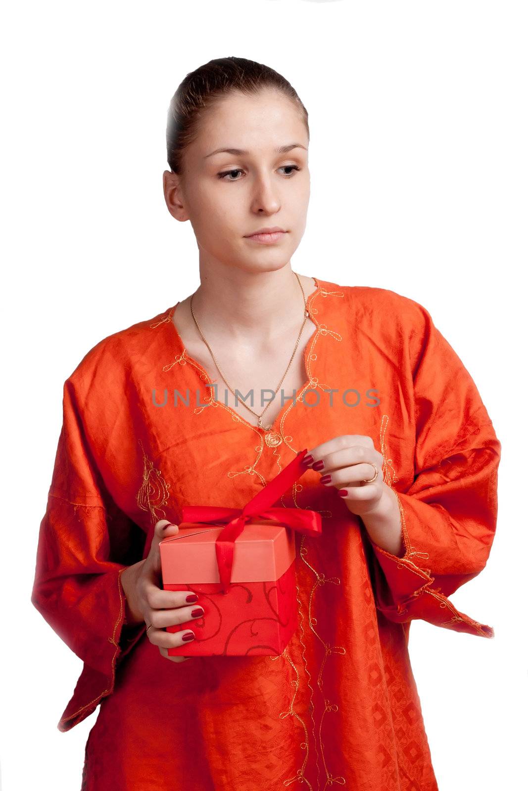 Thoughtful girl in an orange dress opens a gift