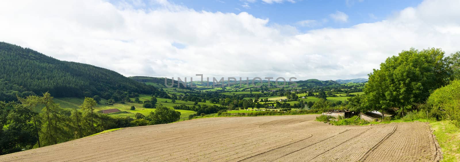 Broad panorama of the countryside in North Wales with ploughed field in foreground