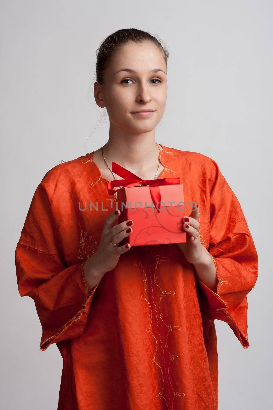 Girl in orange dress with a gift in the hands of by victosha