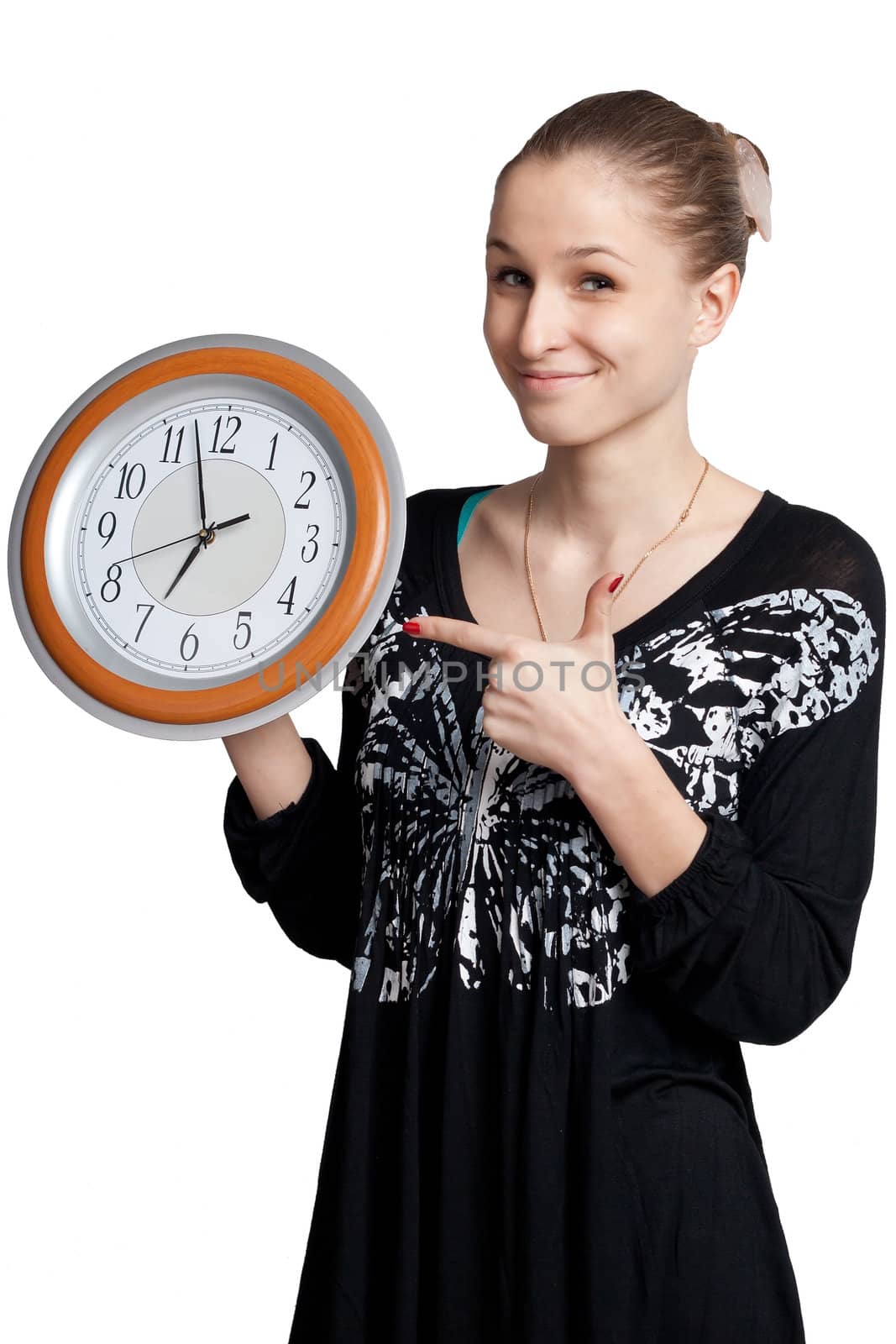 beautiful girl on a white background shows the finger at the large clock in his hand which is almost noon