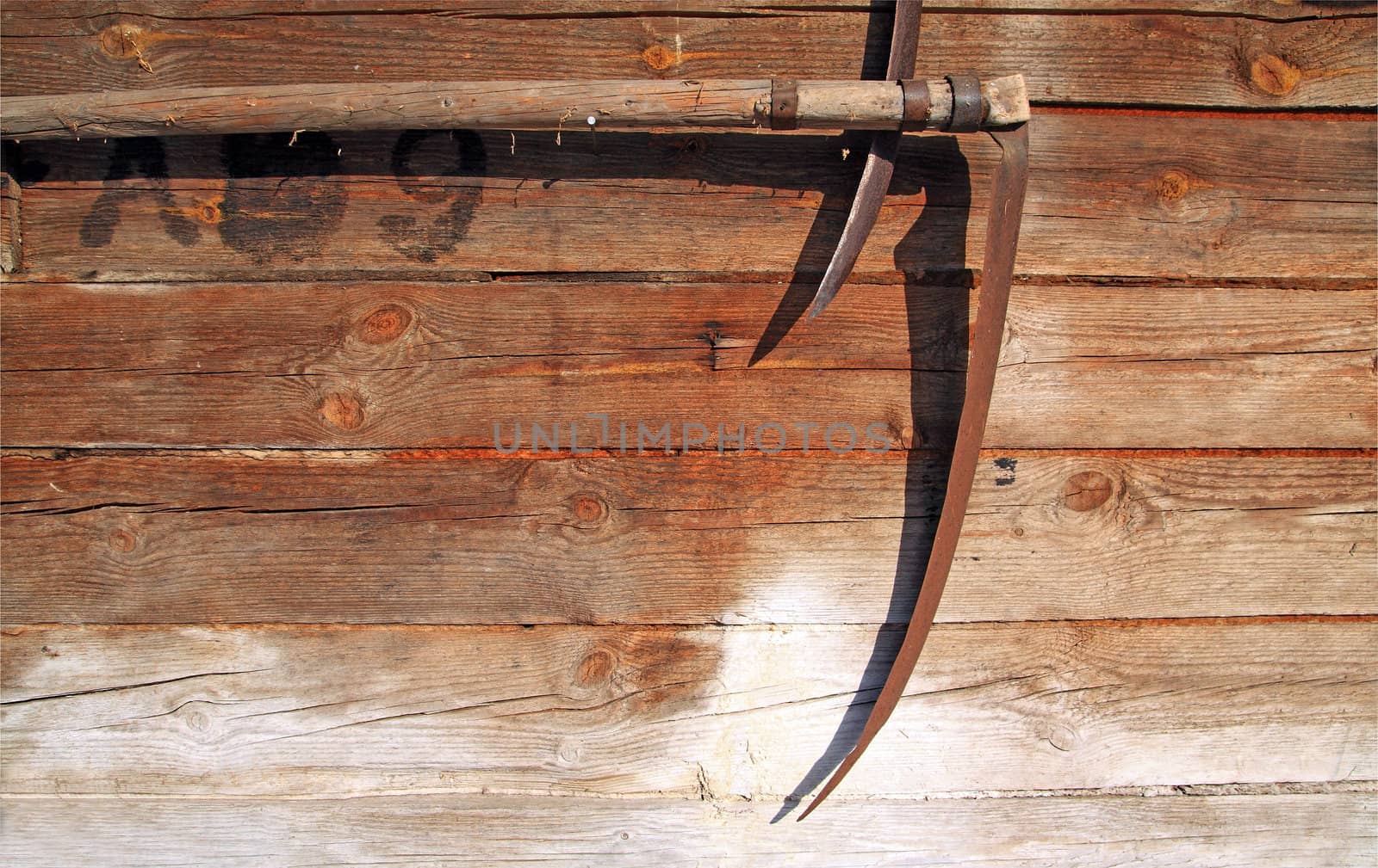 agricultural grunge background, scythe on wooden wall