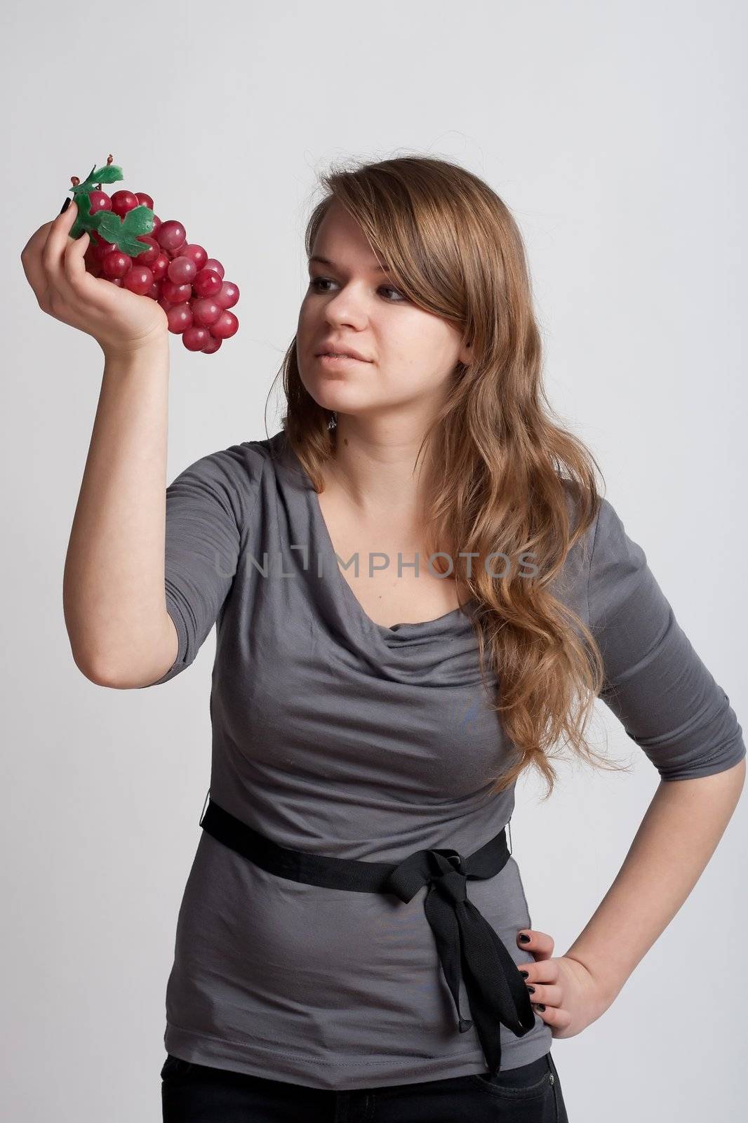 girl on a white background with grapes in his hand