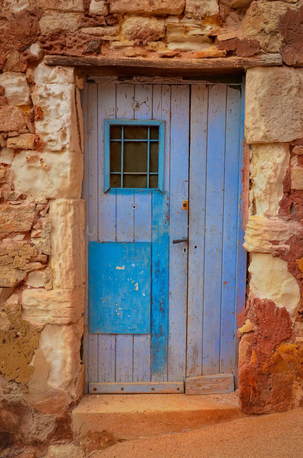 Old textured door in a stone wall, Provence