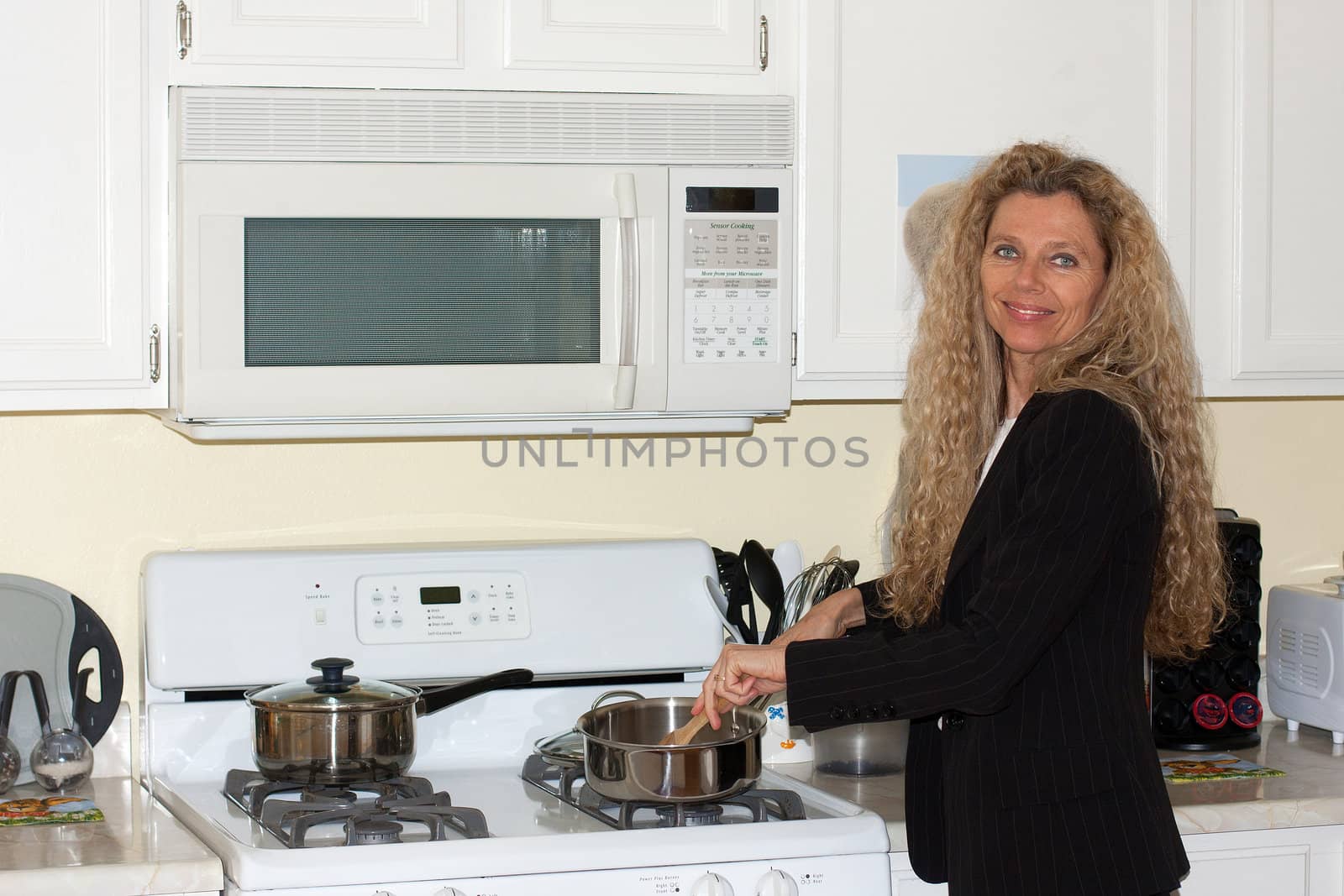 mature woman cooking in the kitchen by the stove