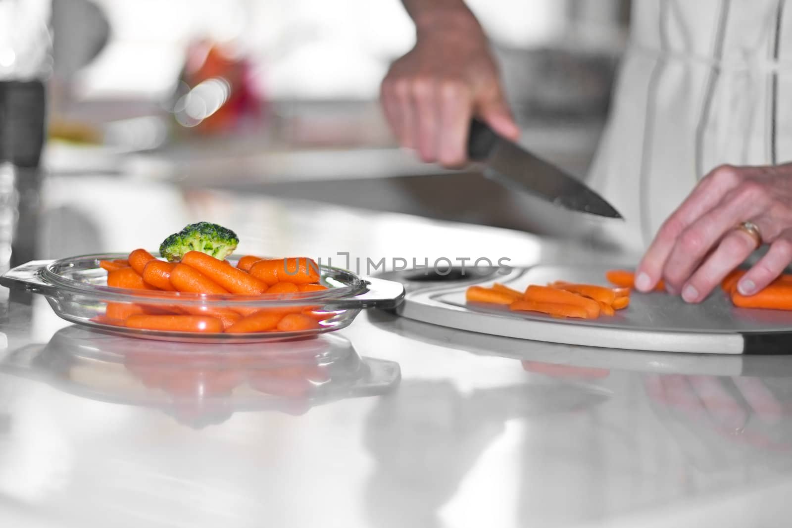 woman cutting carrots on kitchen counter board