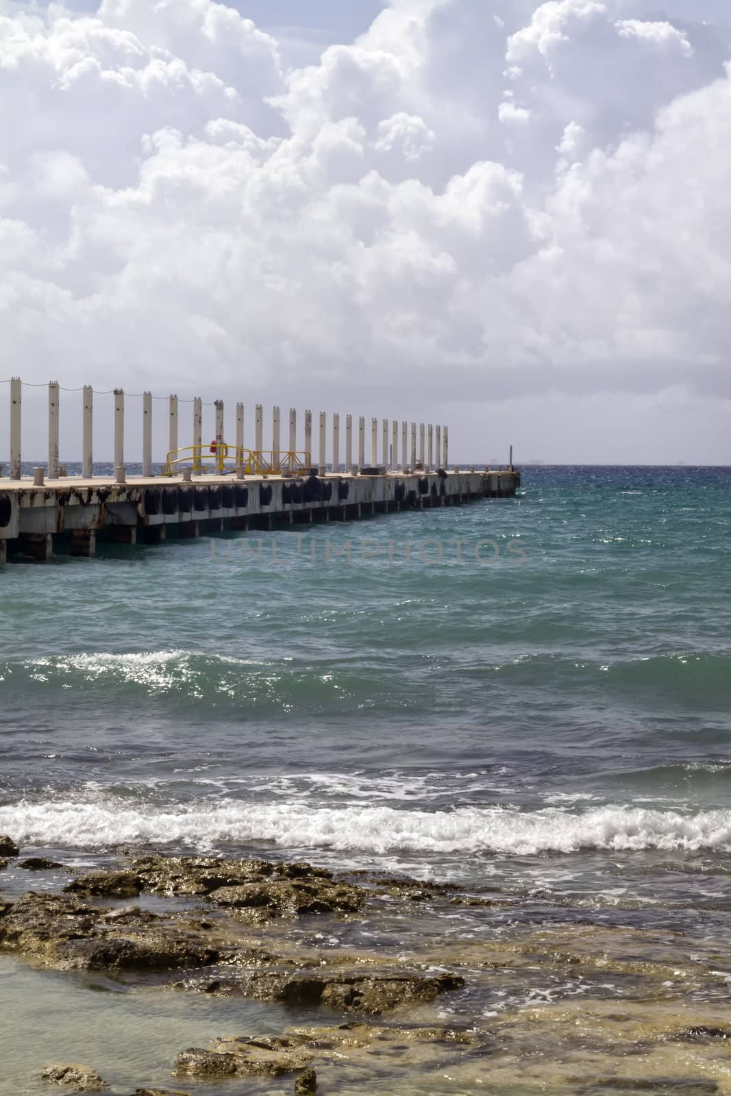 A long pier going out in the tropical ocean
