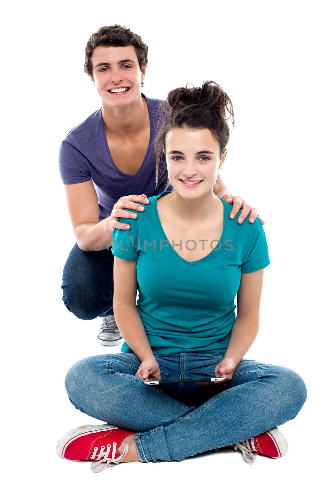 Studio shot of charming young couple. Girl holding tablet pc