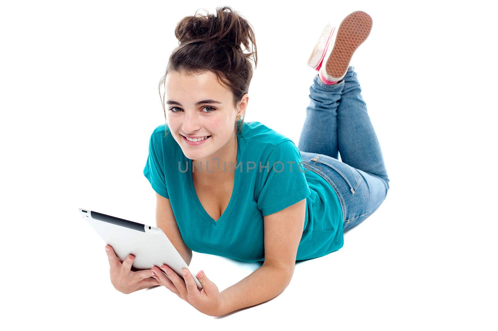 Causal teenager lying on floor holding new tablet pc. Looking at camera