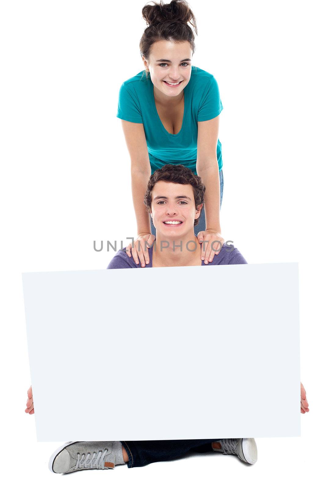 Teens advertising white blank billboard by stockyimages