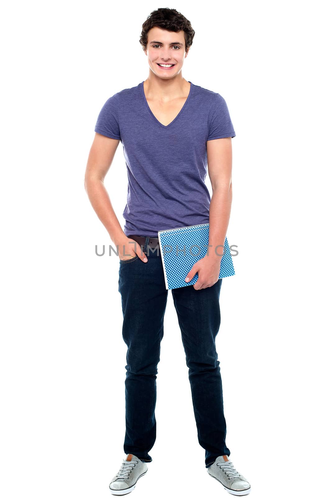 Stylish college student posing with notebook in one hand and other hand in  pocket