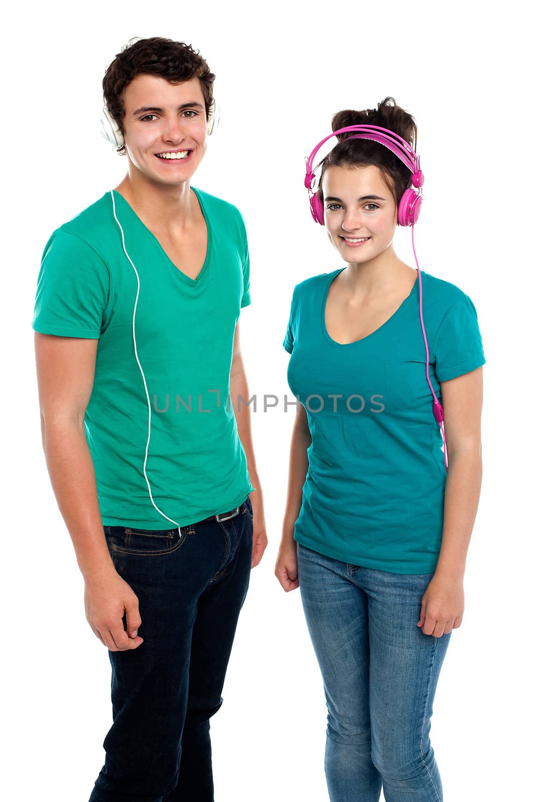 Friends enjoying music together via headphones by stockyimages