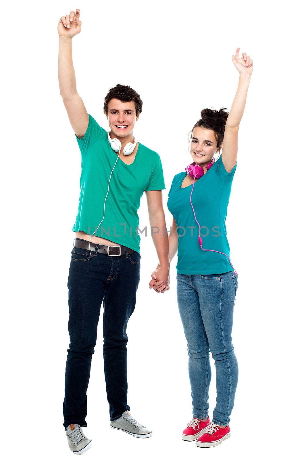 Strong bonding of cheerful teen couple enjoying music by stockyimages
